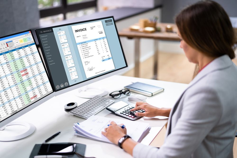 A woman is sitting at a desk working on a computer.