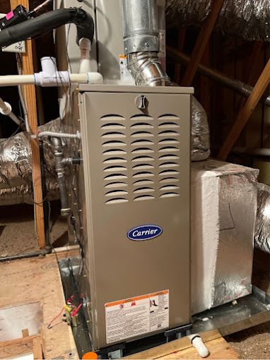 A carrier air conditioner is sitting in the attic of a house.