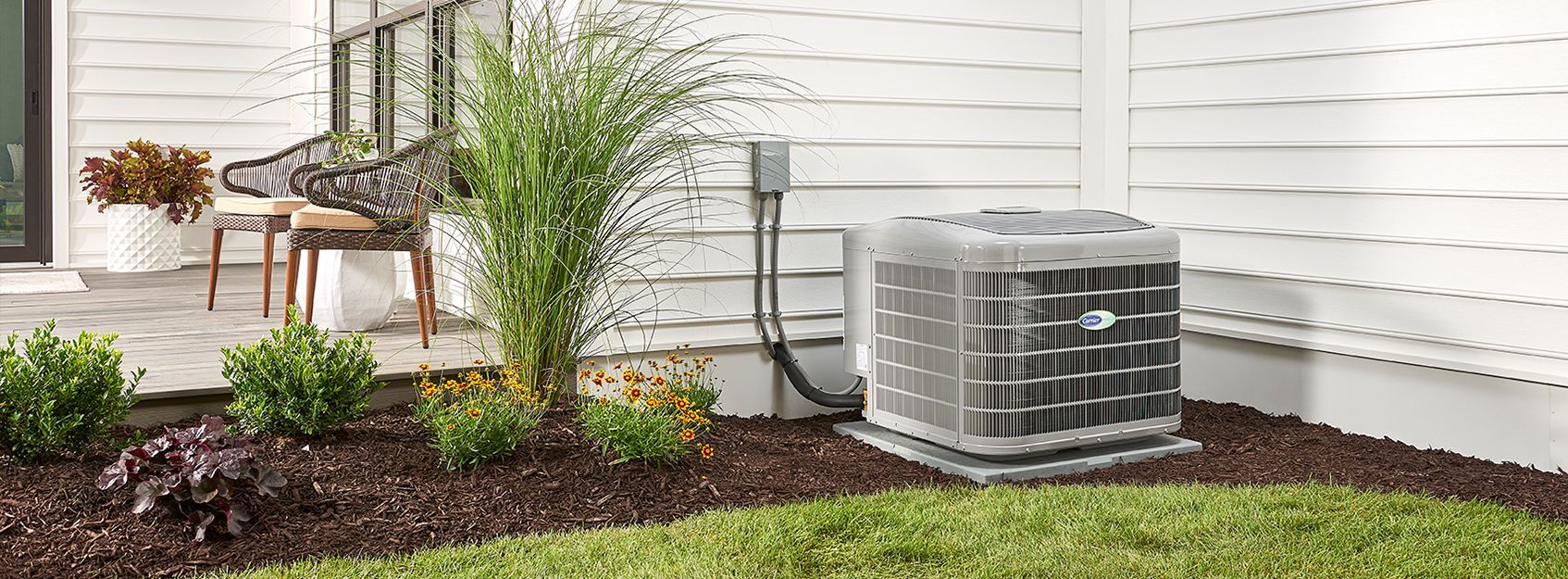 An air conditioner is sitting in the backyard of a house.