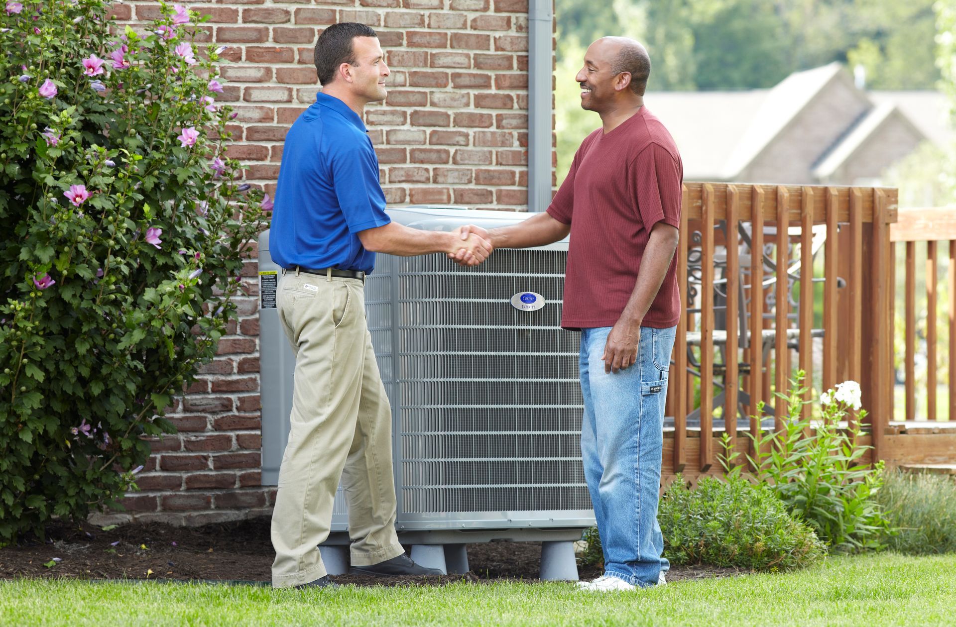 Two men standing next to an air conditioner talking