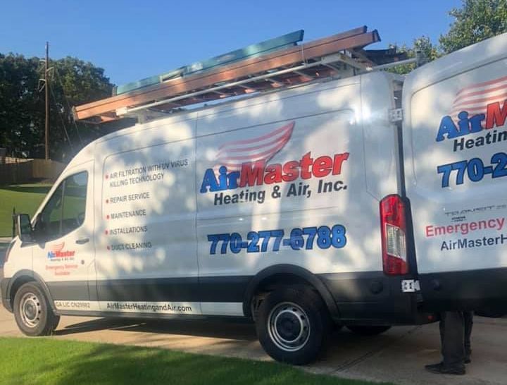 Two airmaster heating and air inc. vans are parked in a driveway.