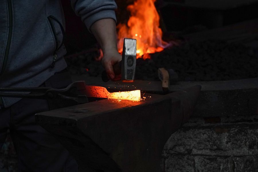 A blacksmith working on a metal rod