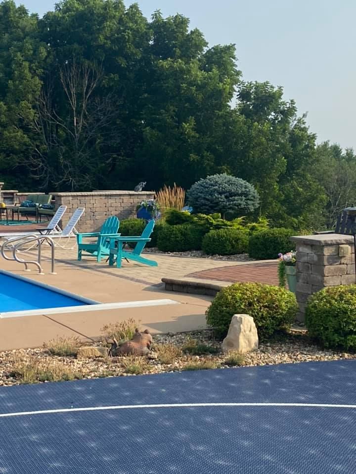 A swimming pool with blue chairs and a basketball court