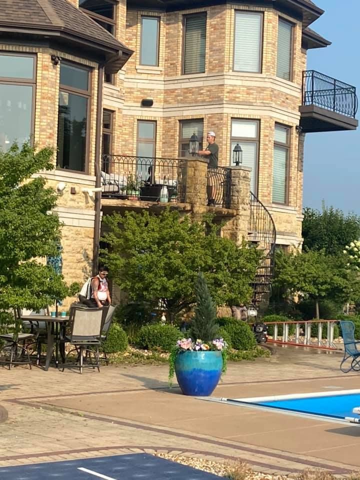 A large brick house with a swimming pool in front of it
