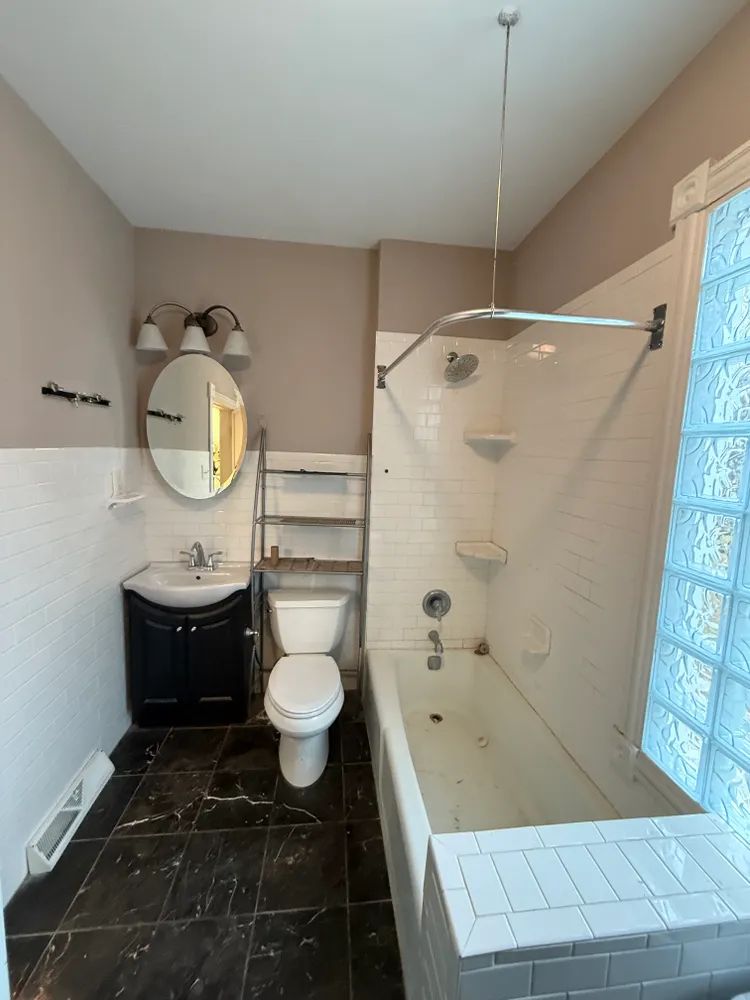 A bathroom with a toilet , sink and bathtub