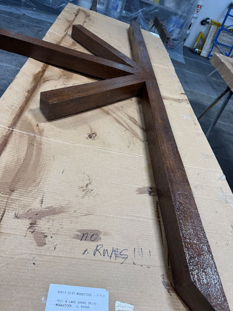 A wooden cross is sitting on top of a wooden table.