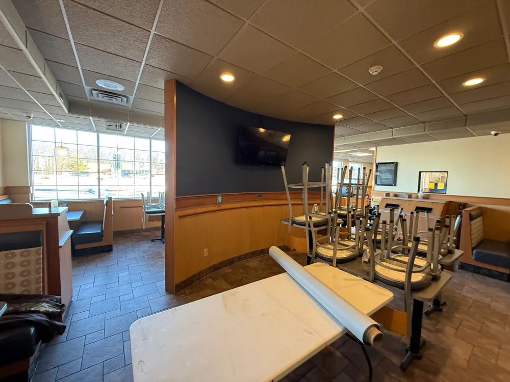 A restaurant with tables and chairs stacked on top of each other.