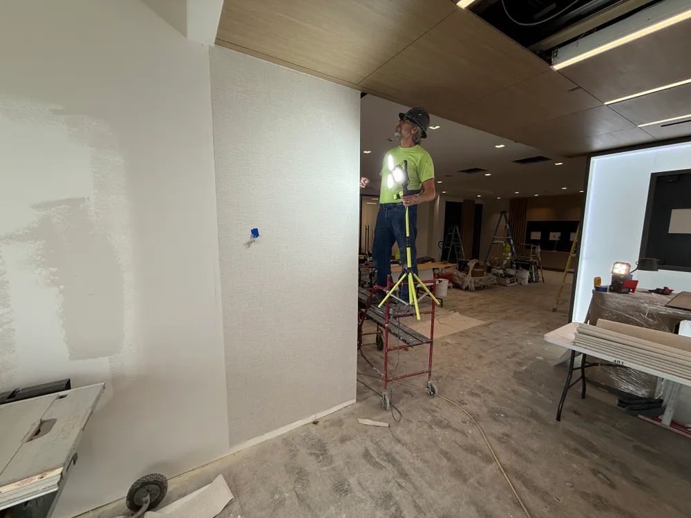 A man is standing on a ladder in a room.