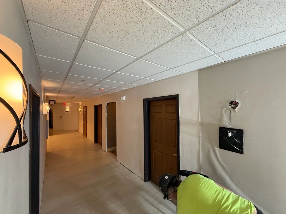 A long hallway with a ceiling that is tiled.