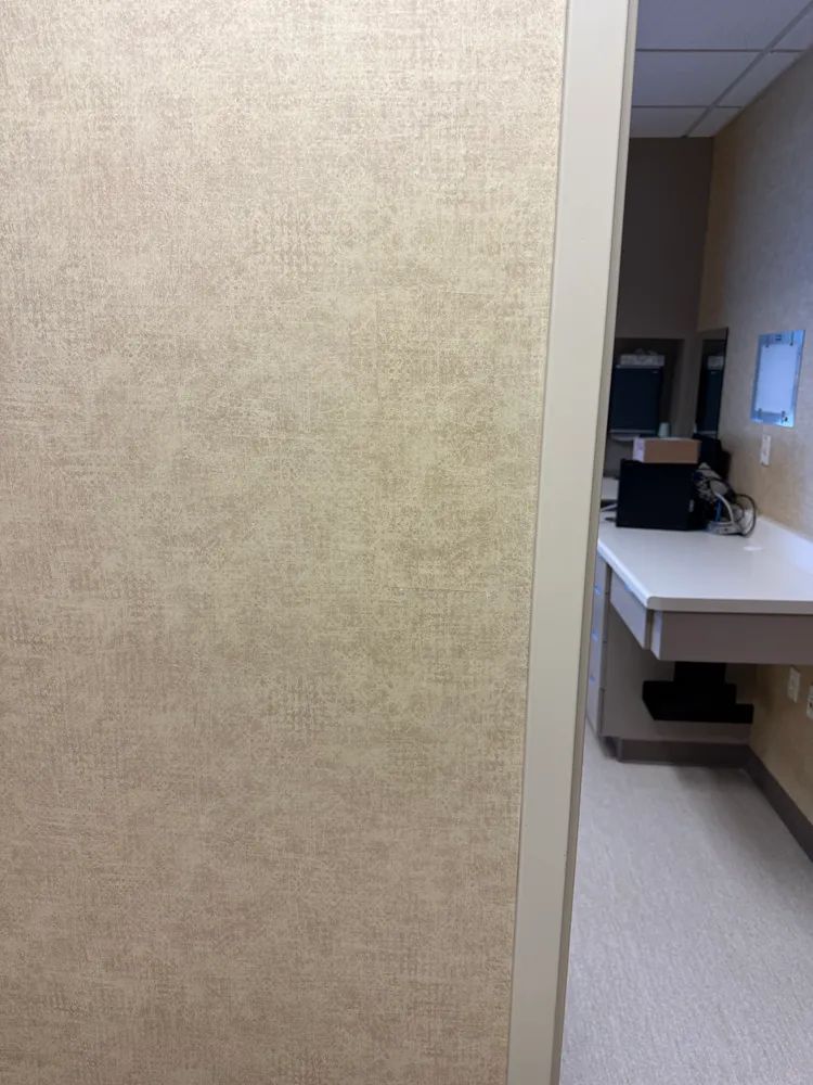 A doorway leading to a room with a desk and a computer on it.