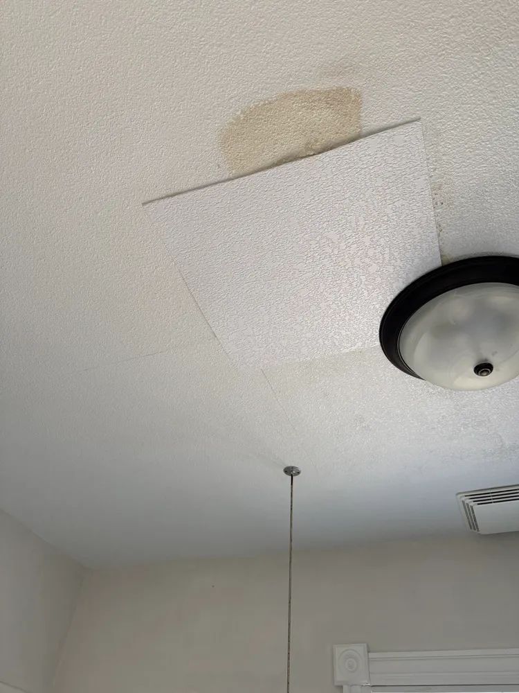 A ceiling with a light fixture hanging from it.