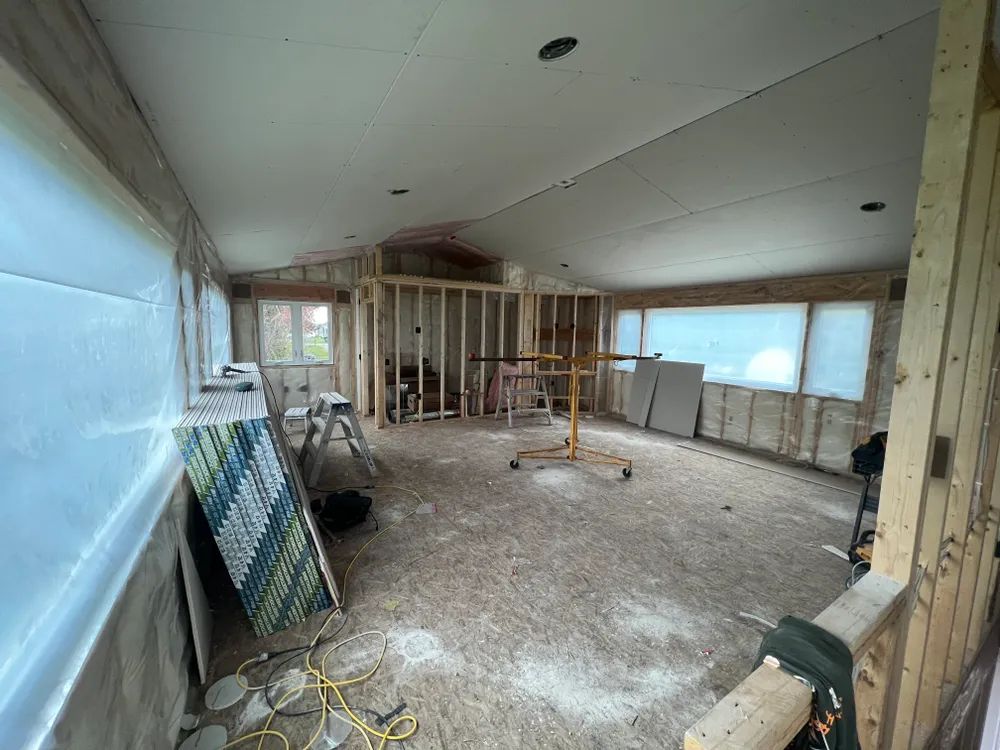 A large room with a lot of windows is being remodeled.