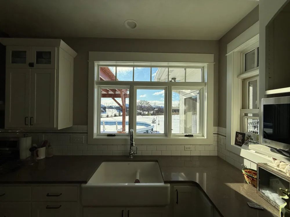 A kitchen with a sink and a large window