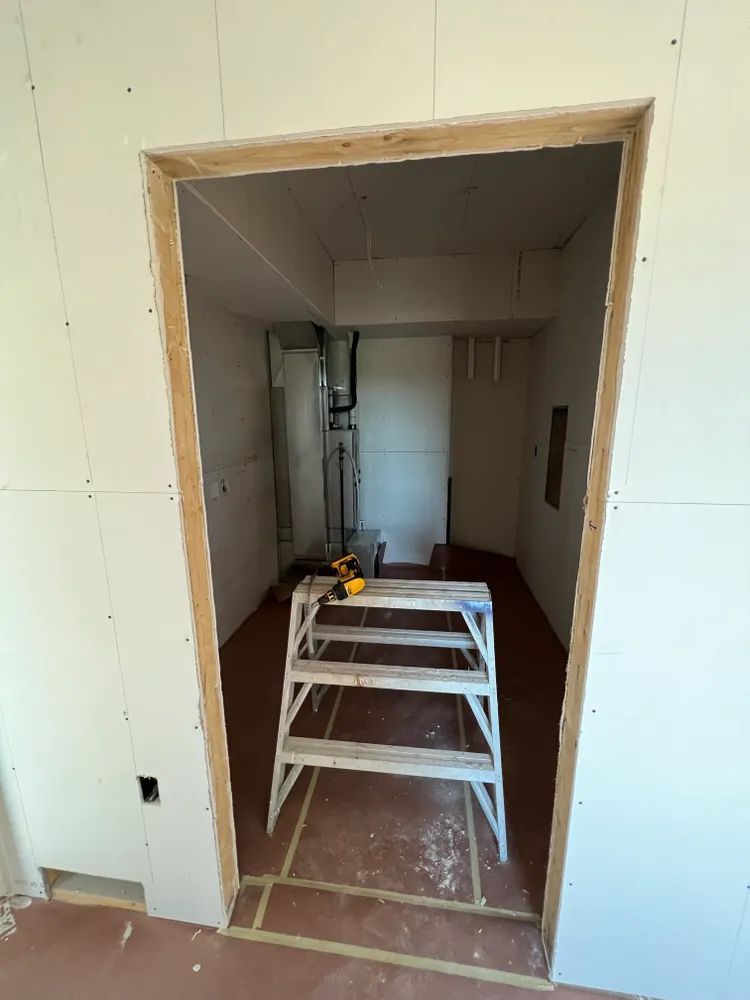 A ladder is sitting in the middle of a room under construction.