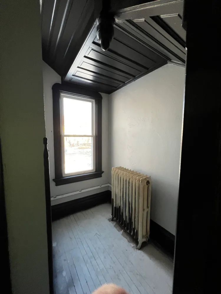 An empty room with a radiator and a window