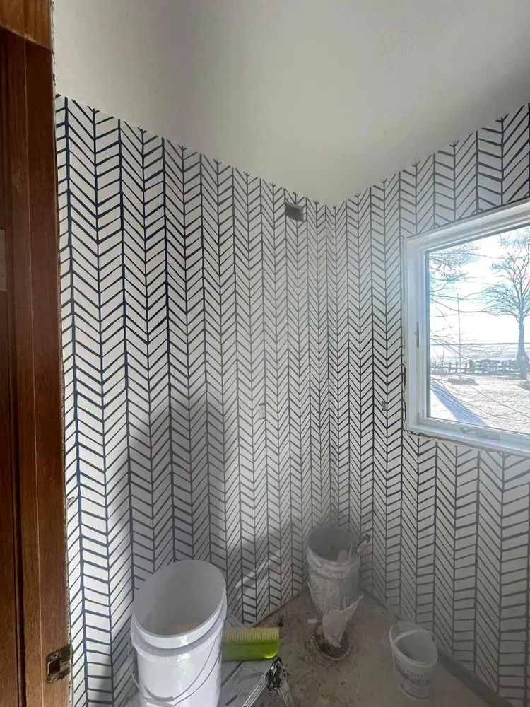 A bathroom with a toilet , shower , and window.