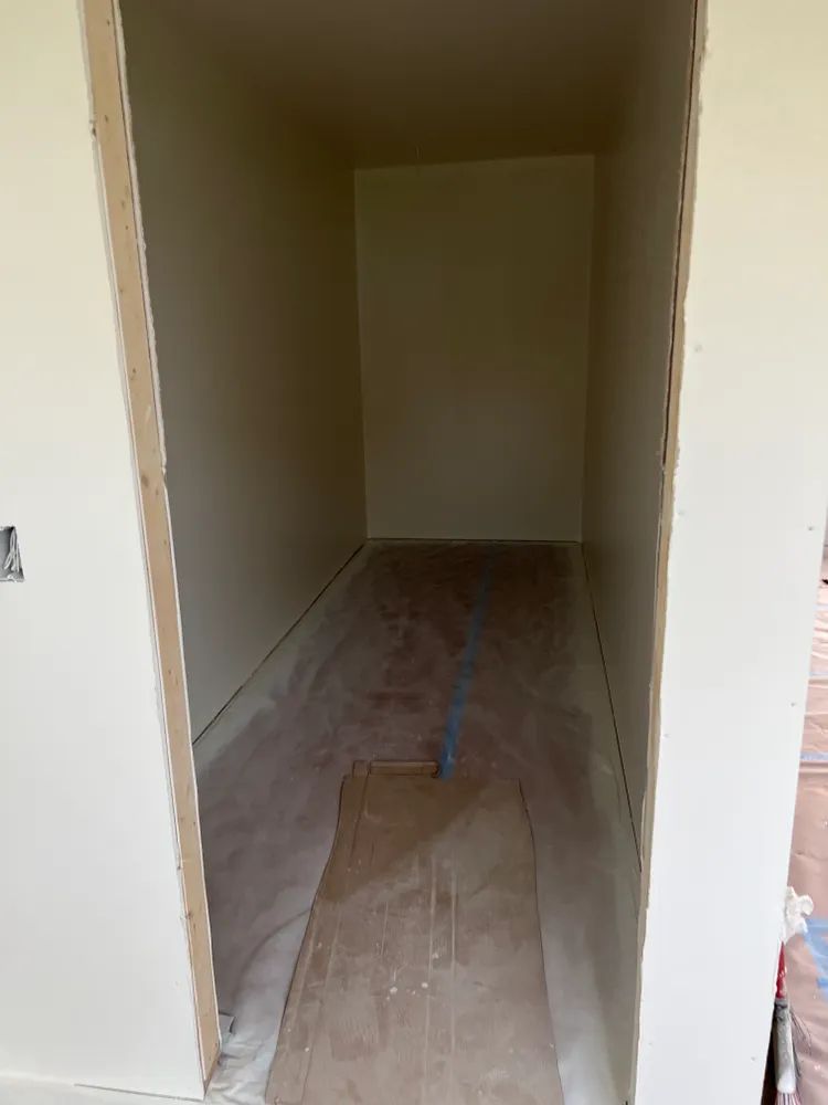 An empty room with a wooden floor and white walls.