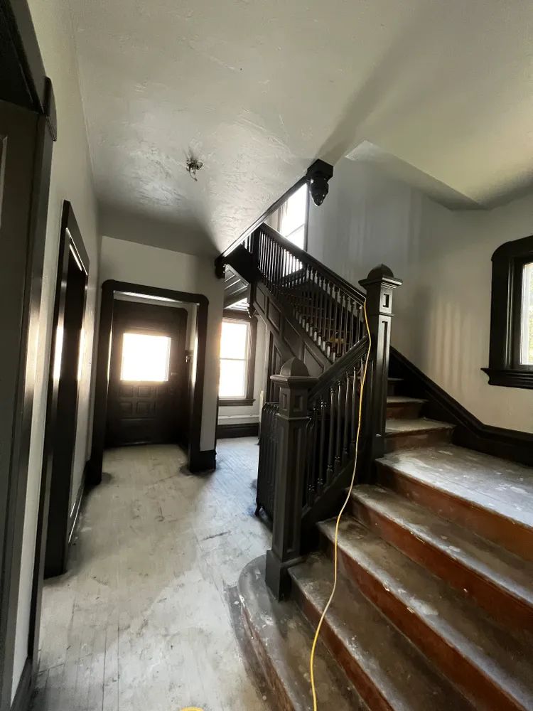 There is a staircase in the middle of a hallway.