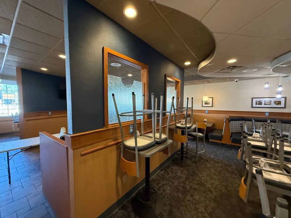 A restaurant with tables and chairs stacked on top of each other.