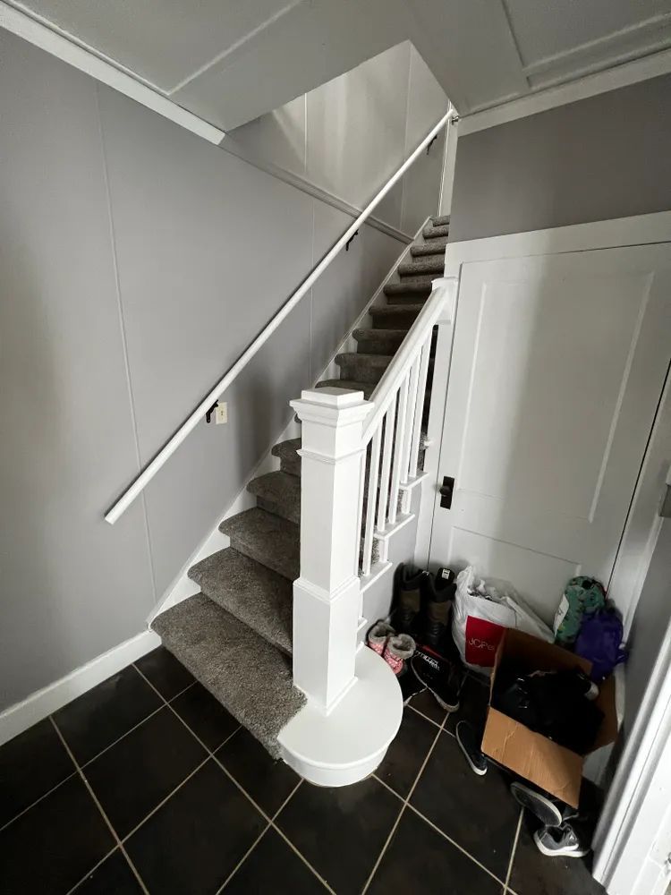 A staircase with a white railing in a hallway