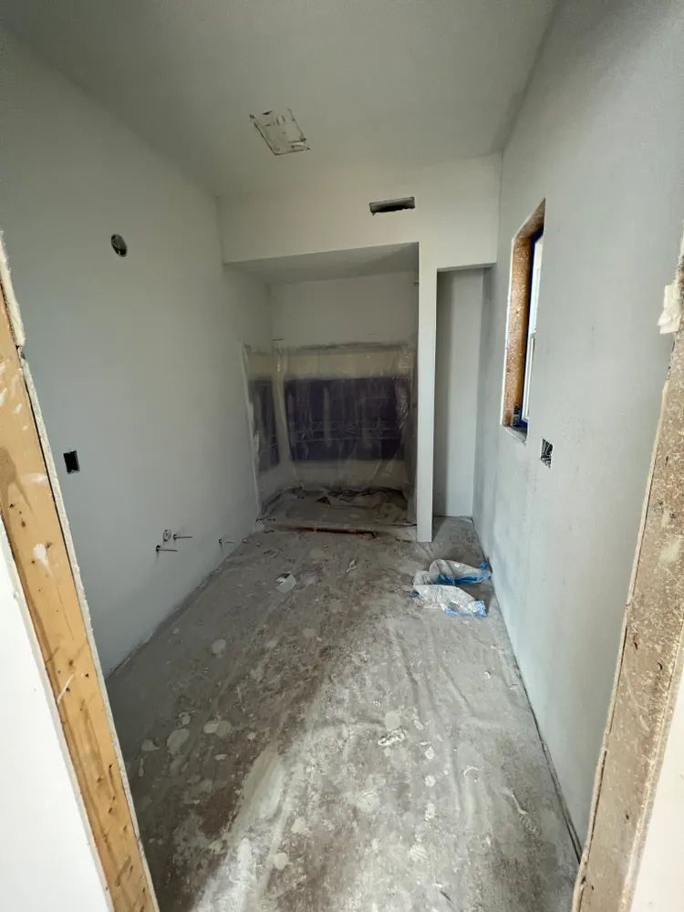 A room that is being remodeled with white walls and a wooden door.