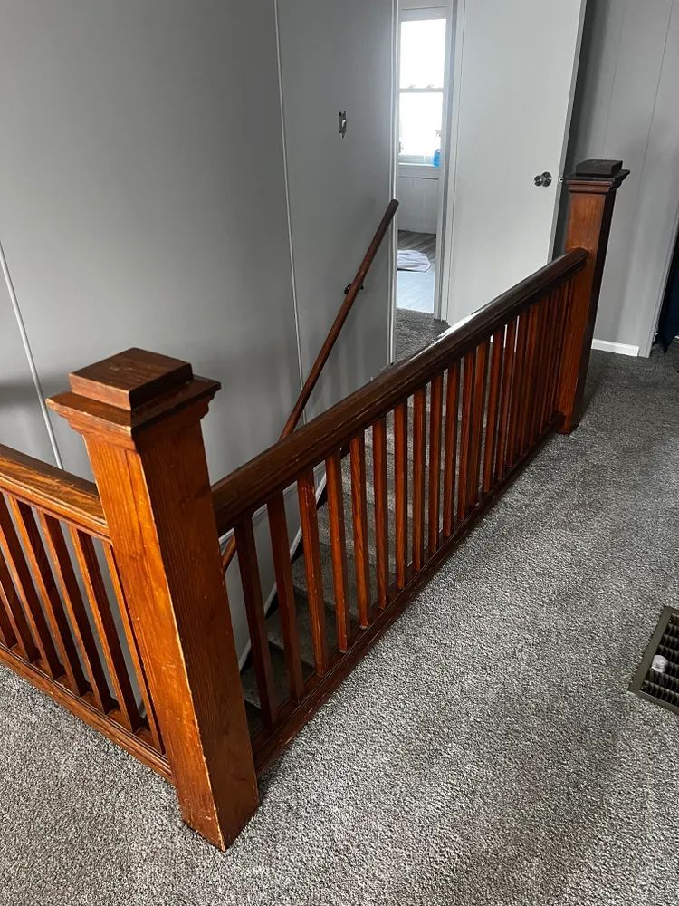 A wooden staircase with a wooden railing in a house.
