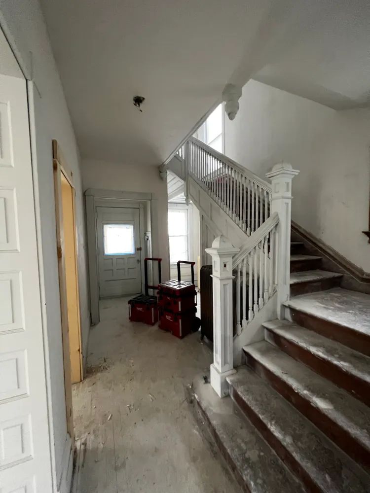 An empty hallway with stairs leading up to the second floor