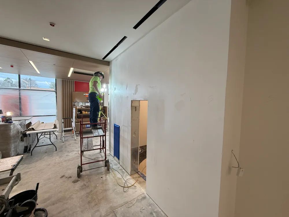 A man is standing on a ladder in a room.