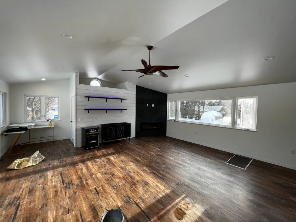 A living room with hardwood floors and a ceiling fan.
