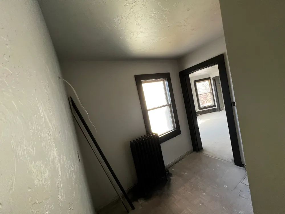 An empty room with a radiator and a window
