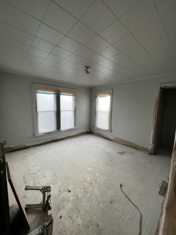 An empty room with a white ceiling and a lot of windows.