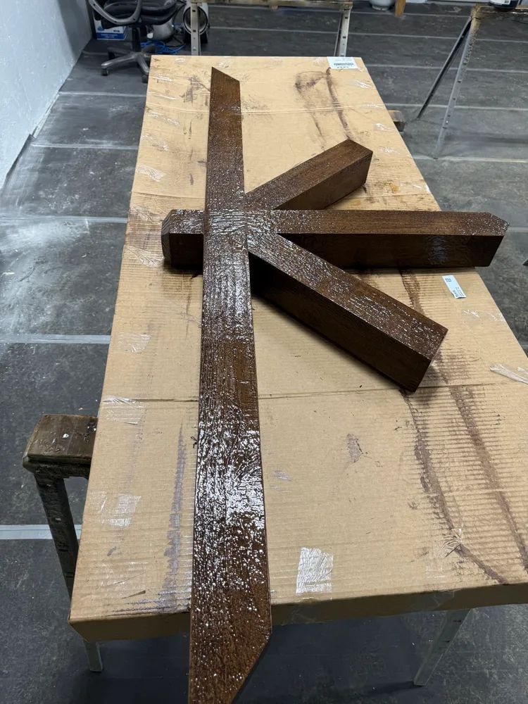 A wooden cross is sitting on top of a wooden table.