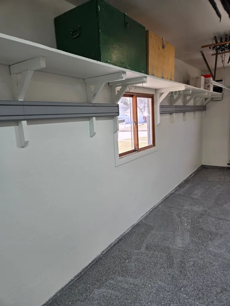 An empty garage with shelves and a window.