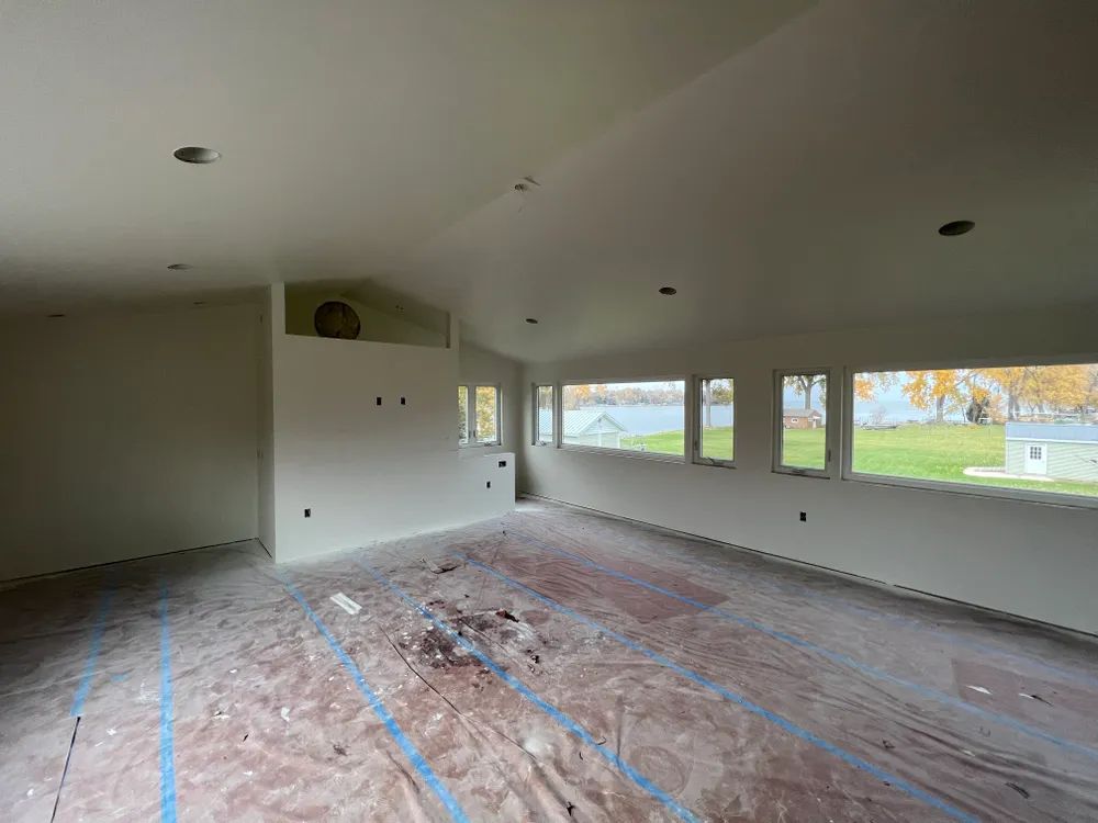 An empty room with a lot of windows and a lot of paint on the floor.