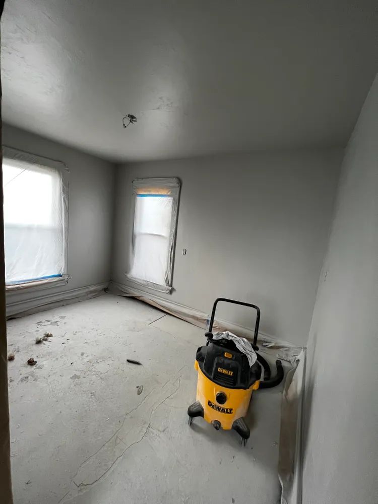An empty room with a yellow vacuum cleaner in it.
