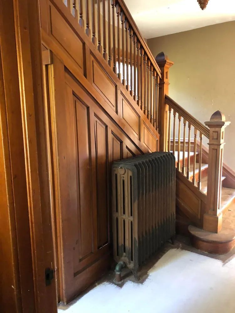 A wooden staircase with a radiator next to it