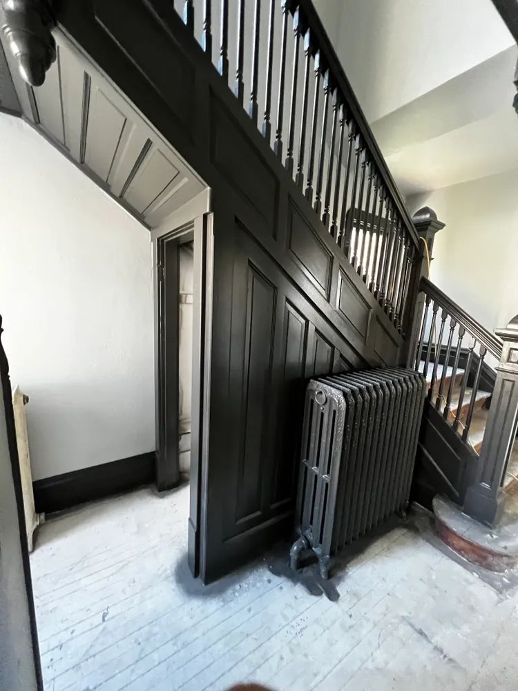 A room with stairs and a radiator on the floor