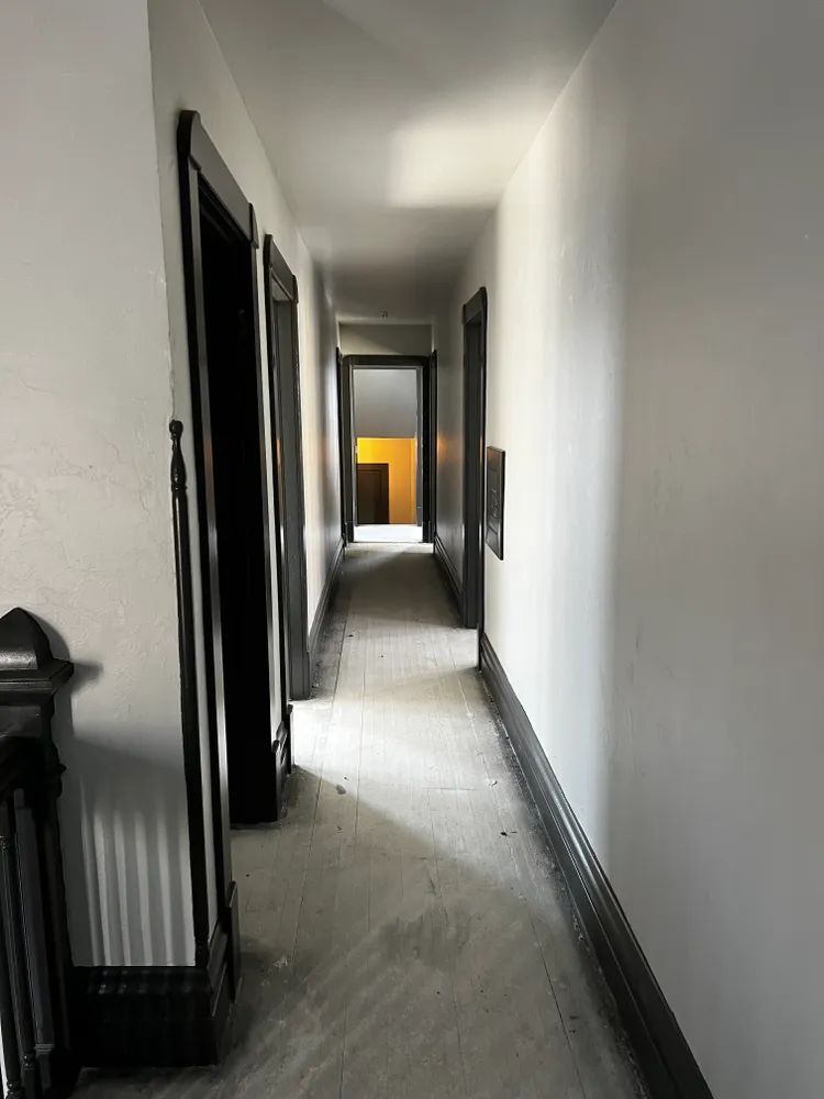 A long hallway with white walls and black trim