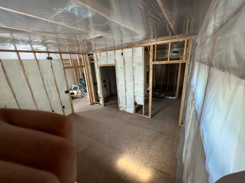 A person is holding a flashlight in a room that is being built.