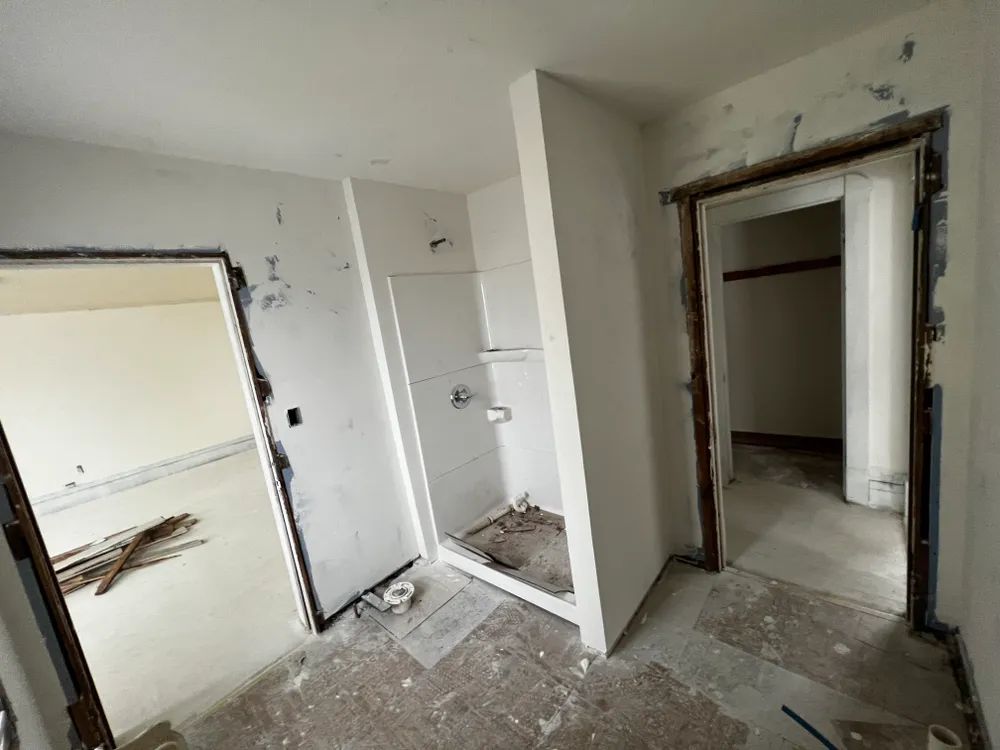 A room with a shower and a door that is open