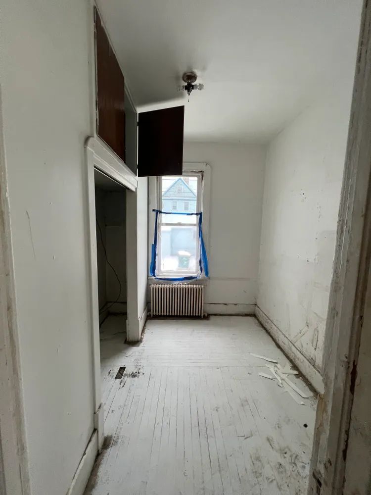 An empty room with white walls and a window.