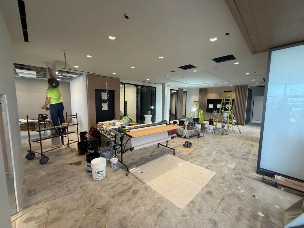 A man is standing on a ladder in a large room.