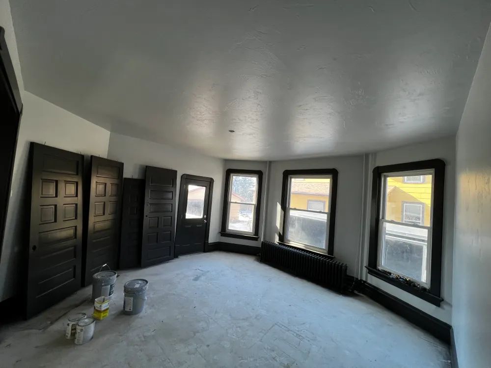 An empty room with a lot of windows and doors