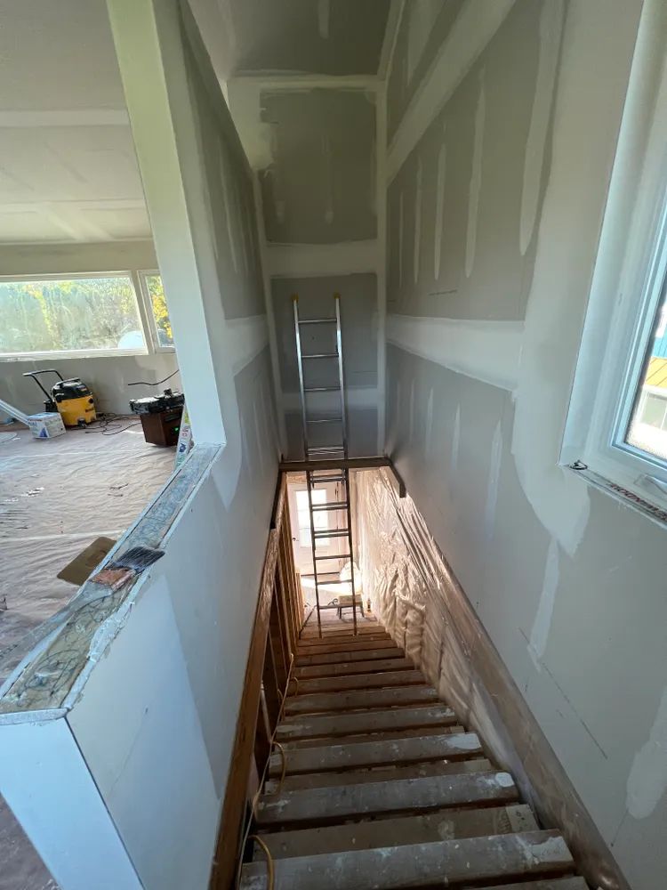 A staircase leading up to a basement with a ladder.