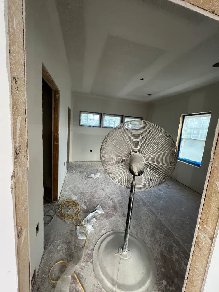 An empty room with a fan in the middle of it.