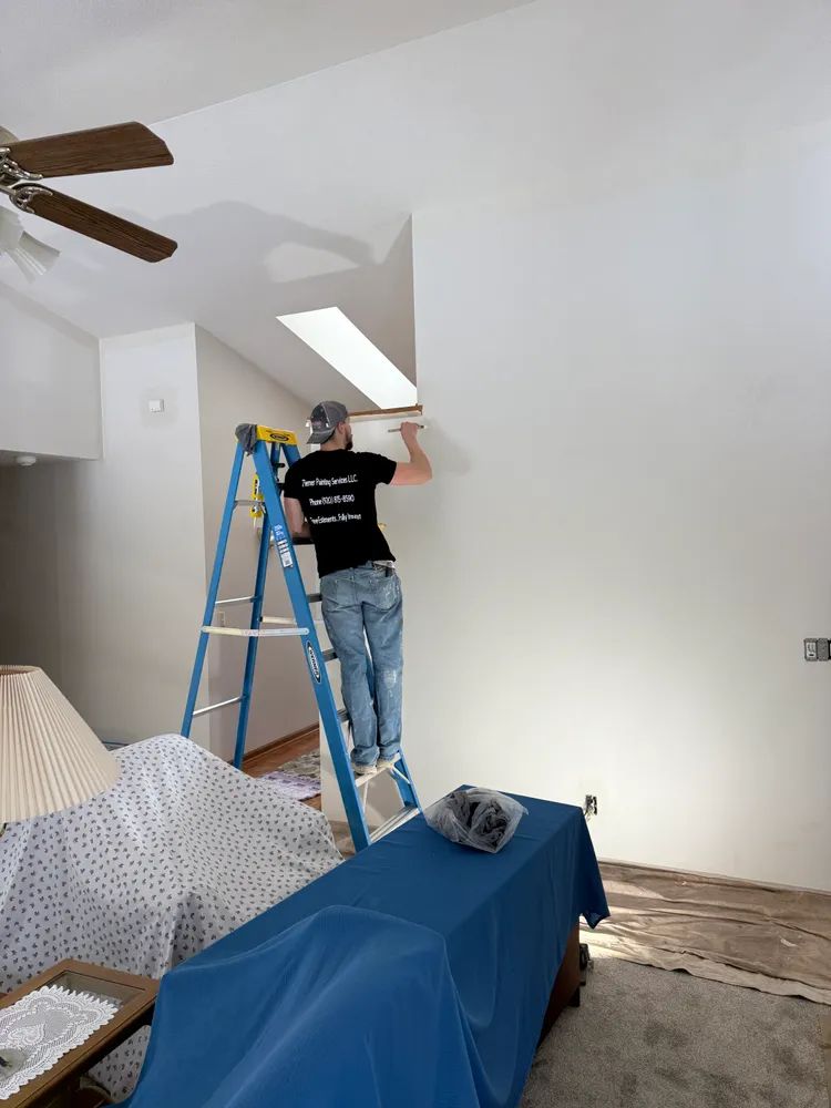 A man standing on a ladder in a living room