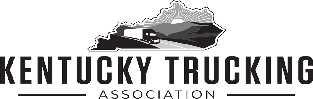 The kentucky trucking association logo is black and white and shows a truck driving down a road.