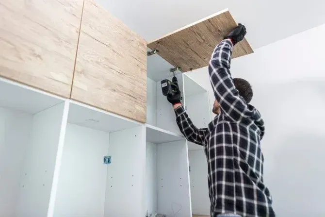 Professional installer fitting a modern cabinet door.