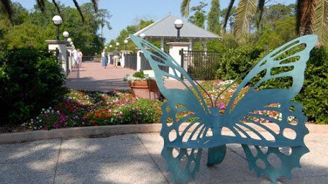 Big metal butterfly in front of an arrangement of Flowers