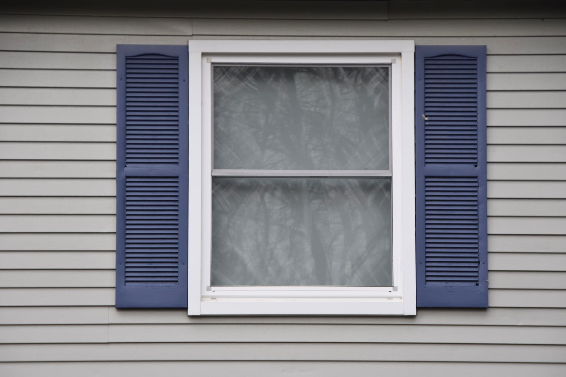 window double hung with blue shutters on house
